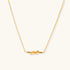 Dainty 18K gold plated necklace with infinity knot pendant on delicate chain against white background