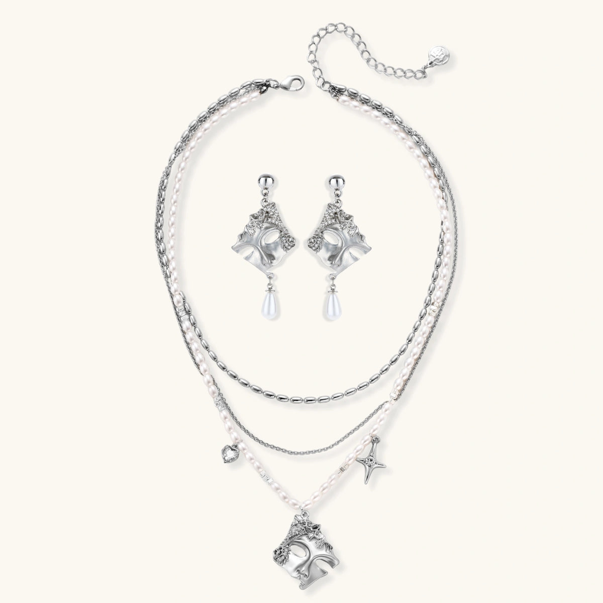 Ornate silver-toned masquerade mask jewelry set featuring rhinestone details and pearl drop earrings on white background.