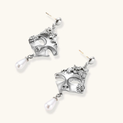 Ornate silver-toned masquerade mask jewelry set featuring rhinestone details and pearl drop earrings on white background.