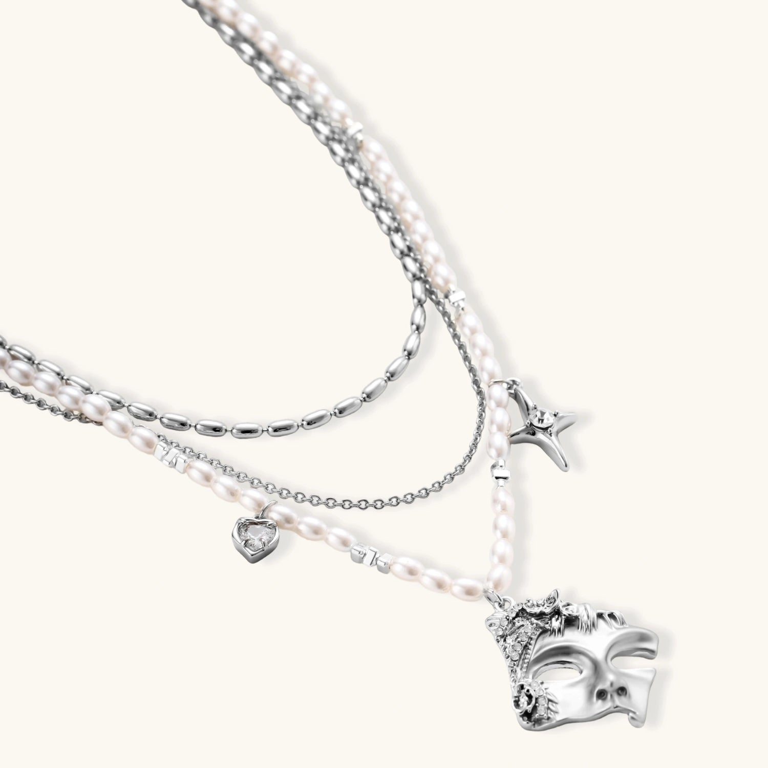 Ornate silver-toned masquerade mask jewelry set featuring rhinestone details and pearl drop earrings on white background.